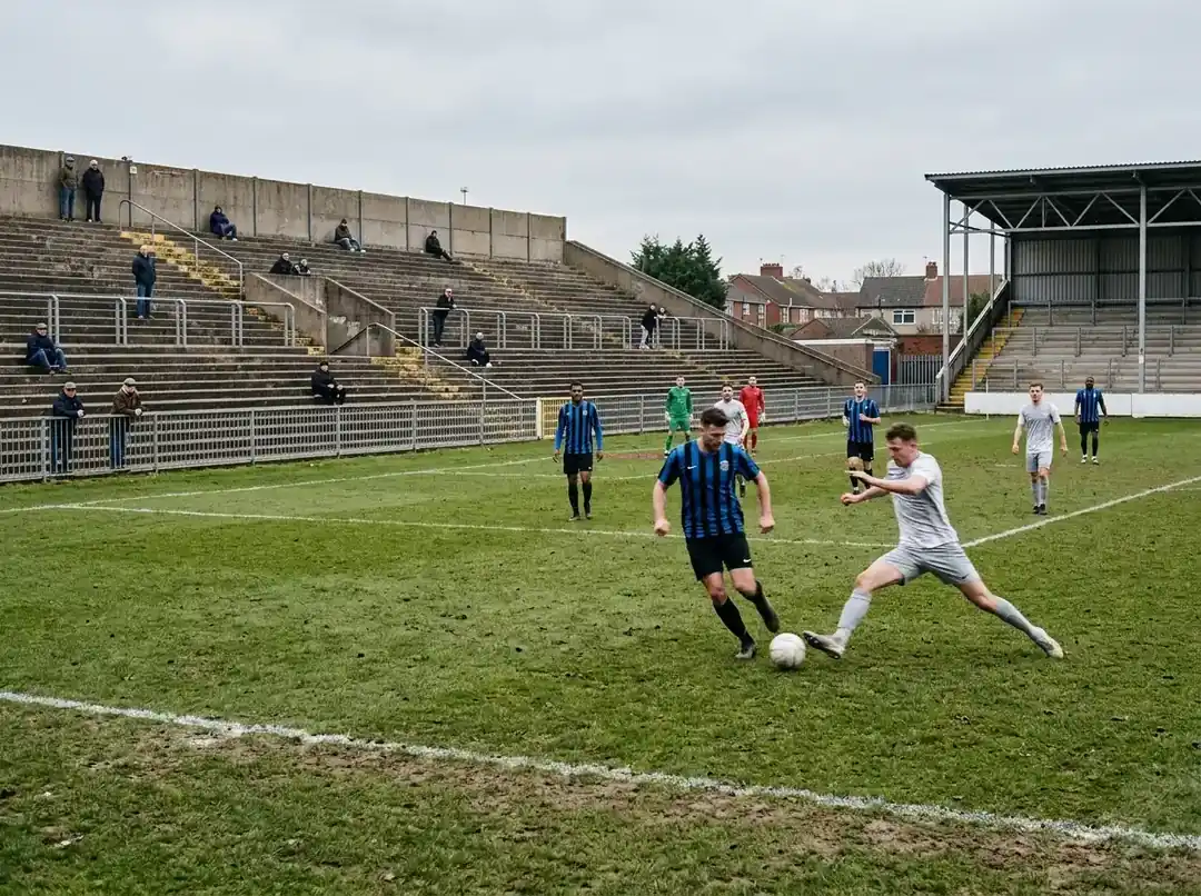 Žemesnės lygos futbolo stadionas tuščiomis tribūnomis rungtynių metu